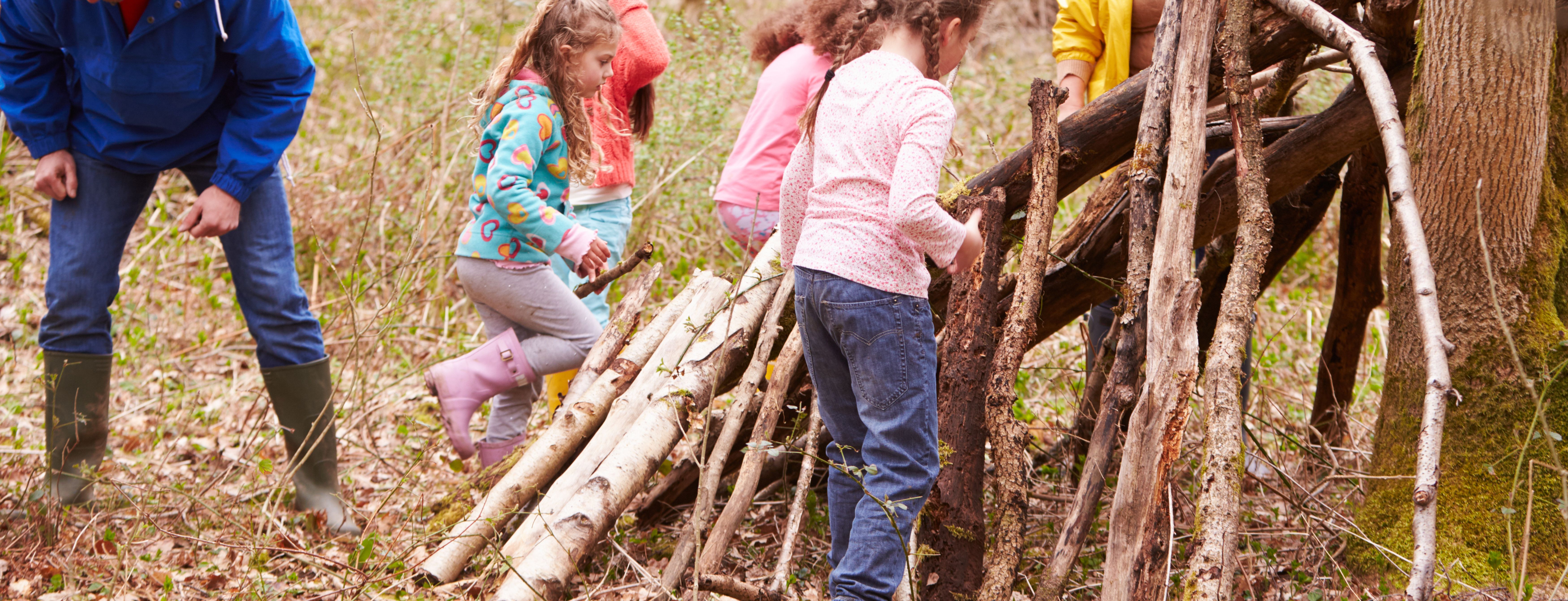 Family building a den with sticks in the forest