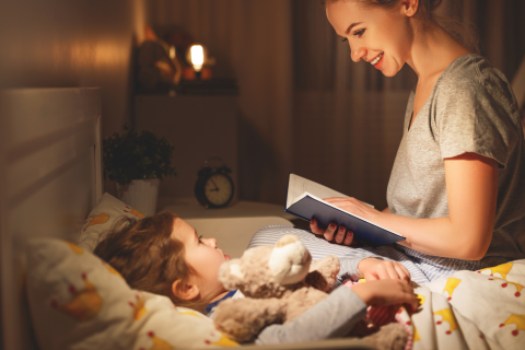 Mother reading to her child in bed