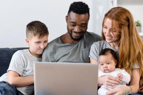 Family using laptop on sofa