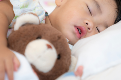 young boy asleep with his teddy bear