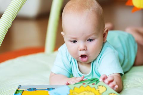 adorable baby looking at a book