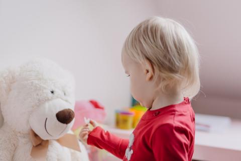 Child giving a teddy a present
