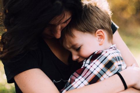 Mother hugs crying son