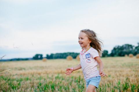 Happy little girl running in a field