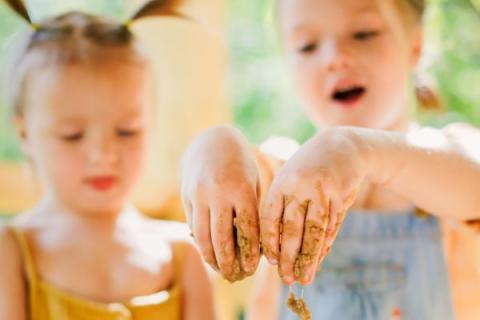 two young children playing with mud