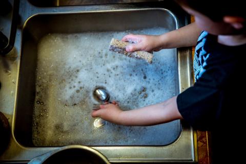 Boy washing dishes