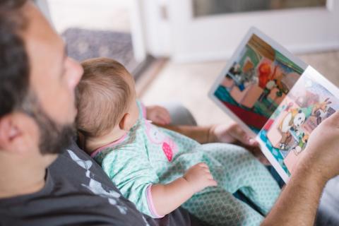 Dad reading to baby for World Book Day