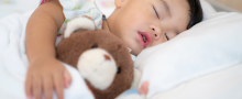 young boy asleep with his teddy bear