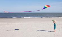 Child flying a kite on a beach