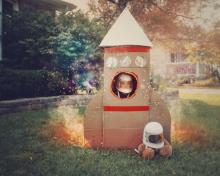 Boy in cardboard rocket