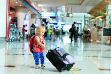 A child pulling a suitcase in an airport