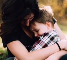Mother hugs crying son