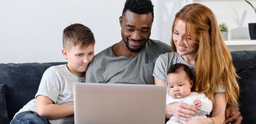 Family using laptop on sofa