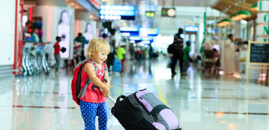 A child pulling a suitcase in an airport