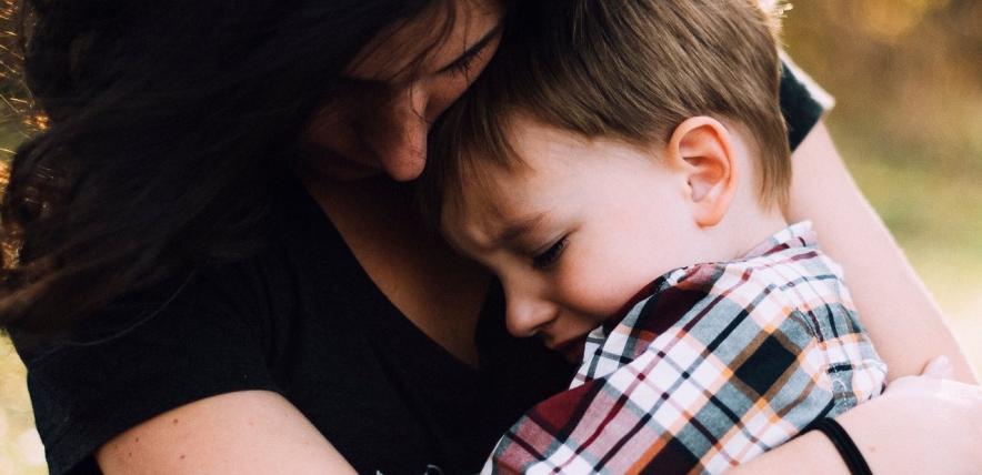 Mother hugs crying son