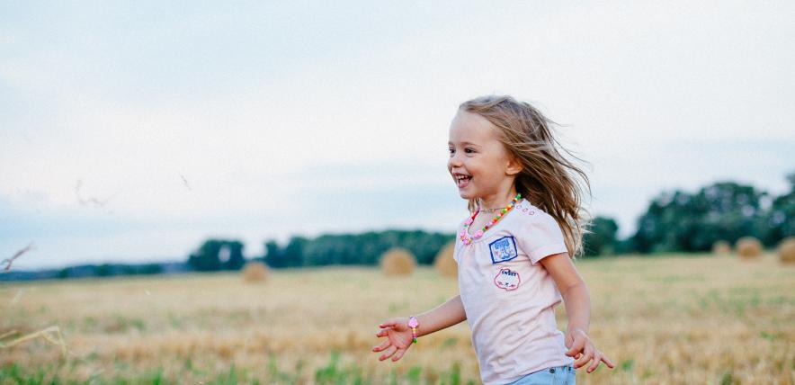 Happy little girl running in a field