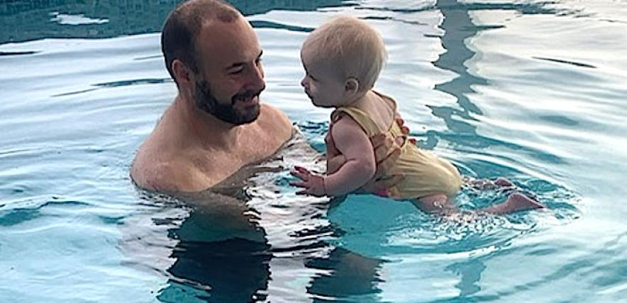 A dad teaching his baby to swim for the first time