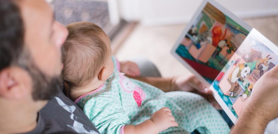 Dad reading to baby for World Book Day